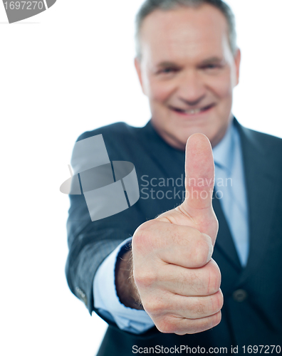 Image of Smiling matured businessman showing thumbs-up