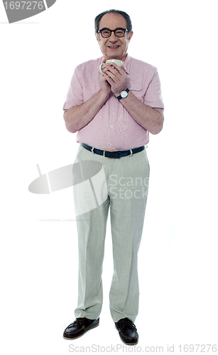 Image of Senior male enjoying hot coffee