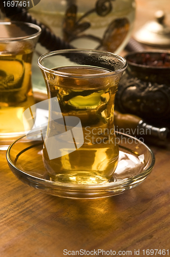 Image of Cup of turkish tea and hookah served in traditional style