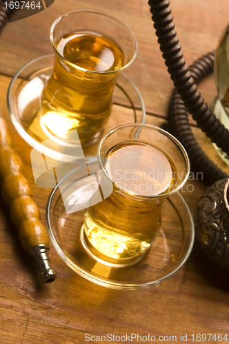 Image of Cup of turkish tea and hookah served in traditional style