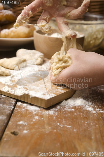 Image of Detail of hands kneading dough