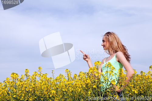 Image of beautiful blonde girl in a field in summer 