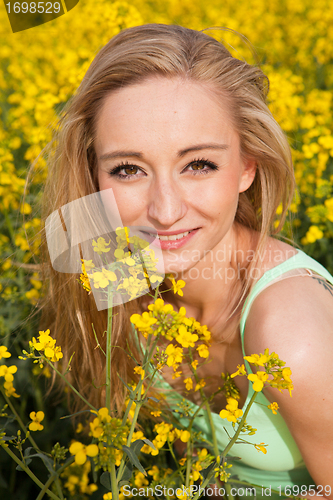 Image of beautiful blonde girl in a field in summer 