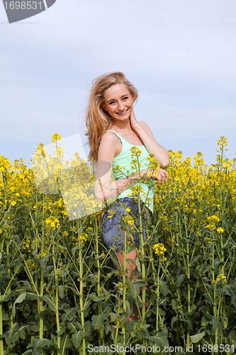 Image of beautiful blonde girl in a field in summer 