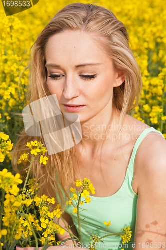 Image of beautiful blonde girl in a field in summer 