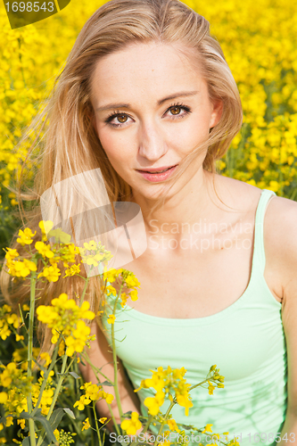 Image of beautiful blonde girl in a field in summer 