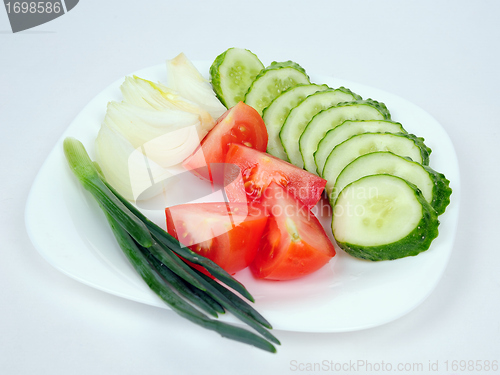 Image of Onions, tomatoes and cucumbers on a plate