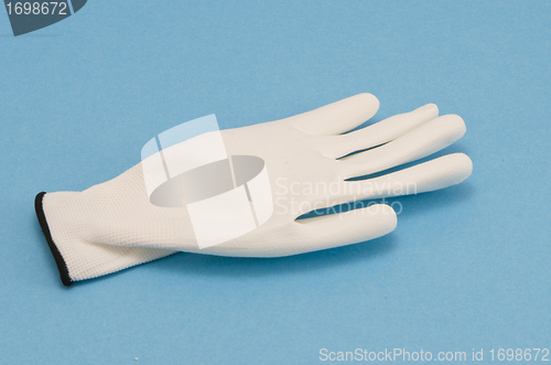 Image of White working glove on blue background 