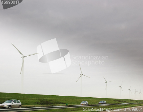 Image of Wind turbines and car on highway