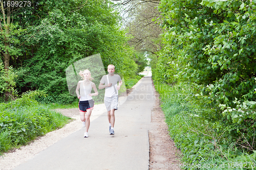 Image of young couple is jogging in the forest