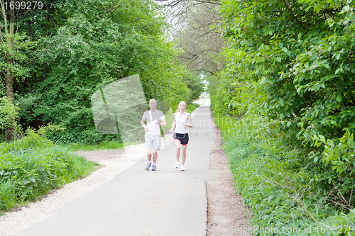 Image of young couple is jogging in the forest