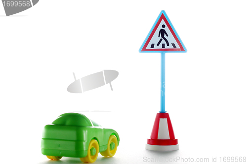 Image of Green car behind pedestrian crossing road sign
