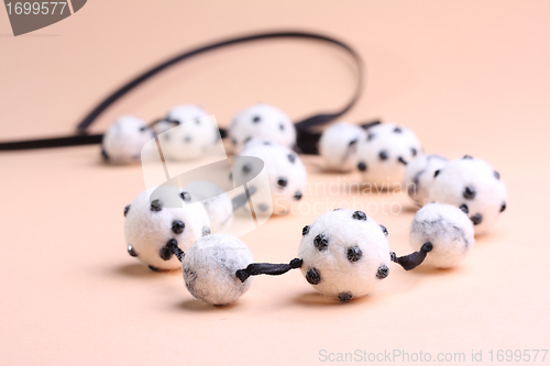 Image of White beads at pink background
