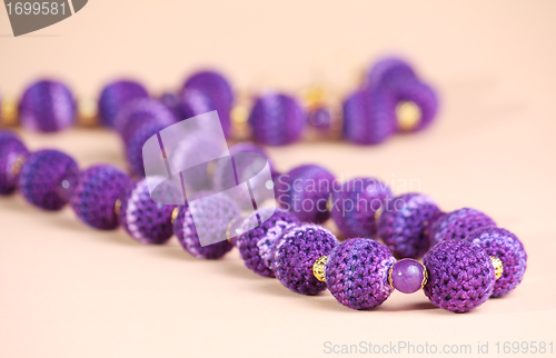 Image of Violet beads at pink background
