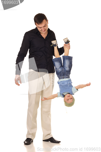 Image of Man holds little boy upside down