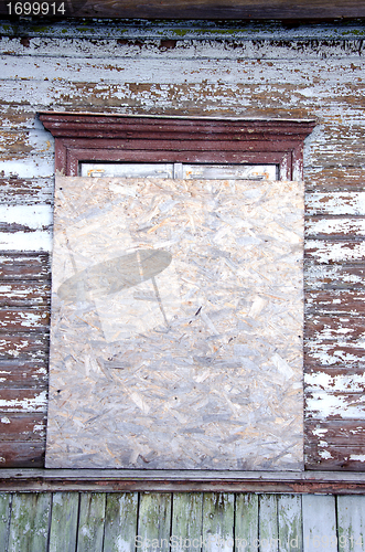 Image of Abandoned house window nailed-up wood chipboard 
