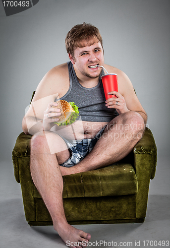 Image of fat man eating hamburger