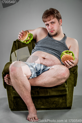 Image of fat man eating hamburger