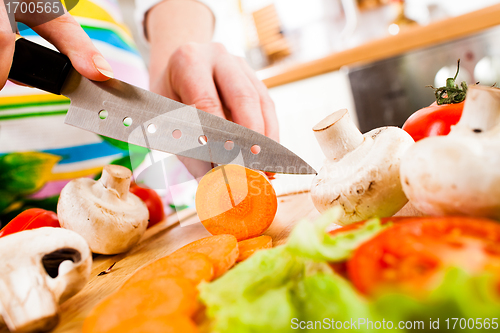 Image of Woman's hands cutting vegetables