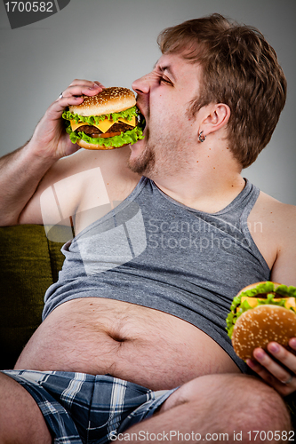 Image of fat man eating hamburger