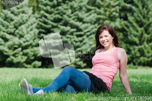 Image of Young happy girl lying on grass