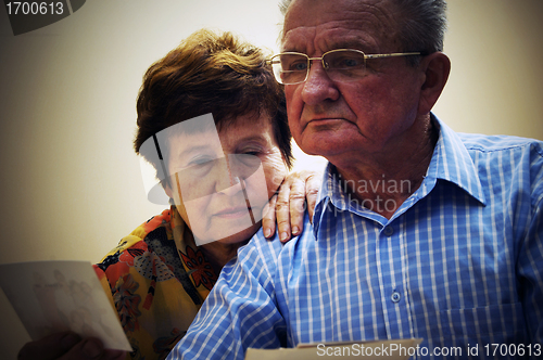 Image of Senior couple looking at old photographs.