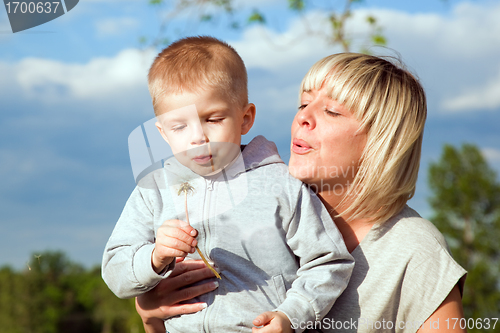 Image of Kid and mother blowing dandelion