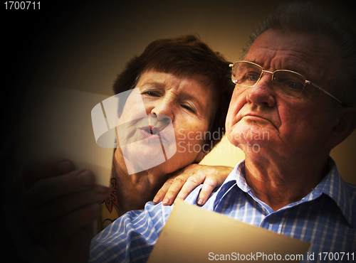 Image of Senior couple looking at old photographs.