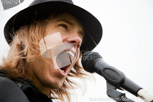 Image of Young man sings to microphone