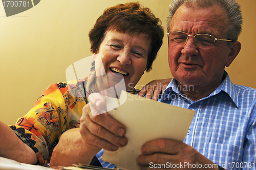 Image of Senior couple looking at old photographs.