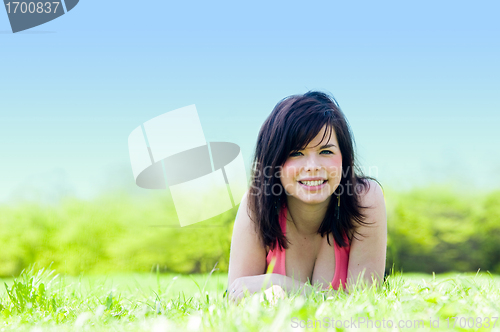 Image of Young happy girl lying on grass