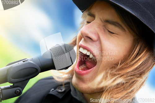 Image of Young man sings to microphone