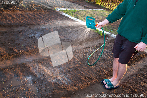 Image of Man watering the ground