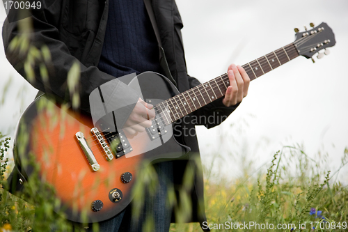 Image of Close up of a man playing guitar