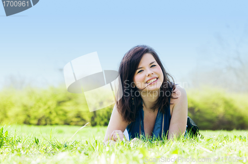 Image of Young happy girl lying on grass