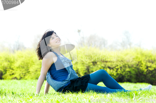 Image of Young happy girl lying on grass