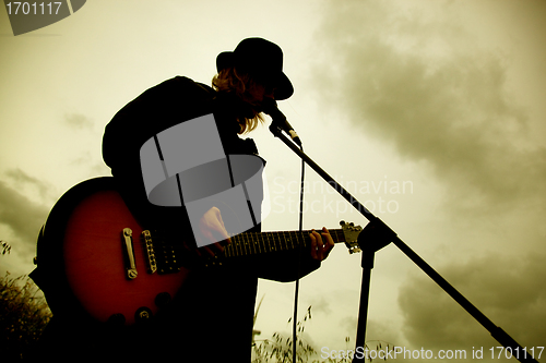 Image of Man playing guitar outdoors