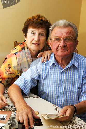 Image of Senior couple looking at old photographs.