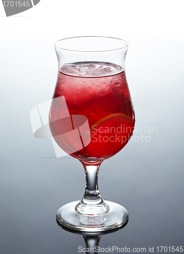 Image of glass of fresh red cocktail with lime and ice