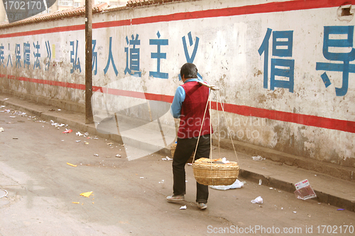 Image of Woman transporting goods in China