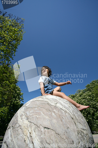 Image of Child on a spherical rock