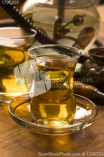 Image of Cup of turkish tea and hookah served in traditional style