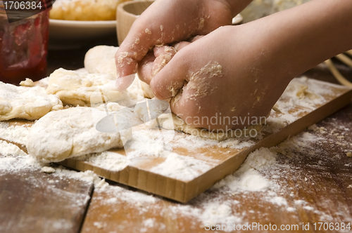 Image of Detail of hands kneading dough