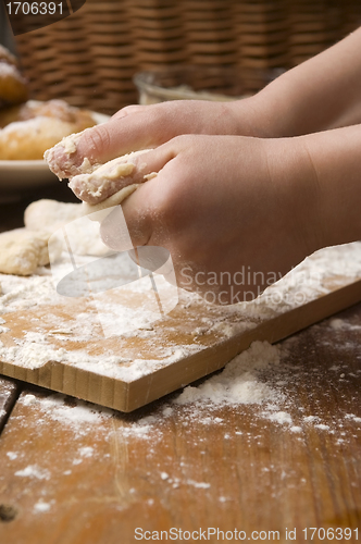 Image of Detail of hands kneading dough