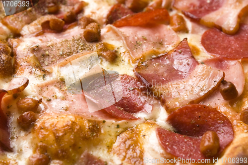 Image of Italian pizza with bacon, salami and mozzarella cheese