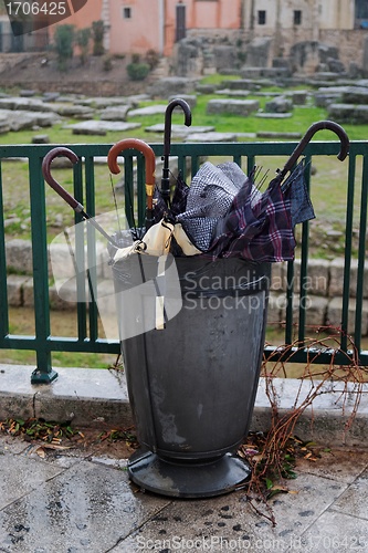 Image of Trash bin full of broken umbrellas