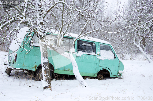 Image of Old broken minibus covered with snow winter garden 