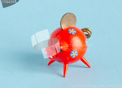 Image of Red piggybank with pfennig on blue background 