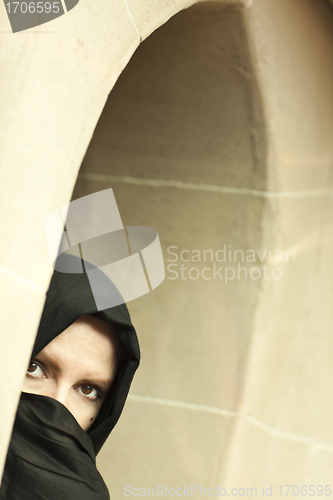 Image of Cautious Islamic Woman in Window Pane Wearing Burqa or Niqab