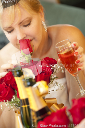 Image of Blonde Woman Smells Roses at Mirror Near Champagne